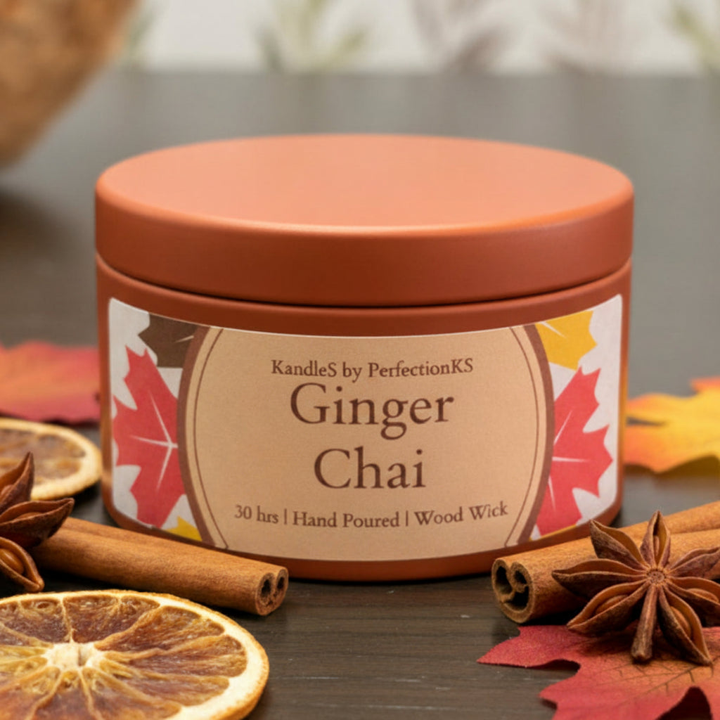 A round terracotta-colored candle tin labeled 'Saffron Spice' by Kandles by PerfectionKS, sitting on a dark wooden surface with a softly blurred background.