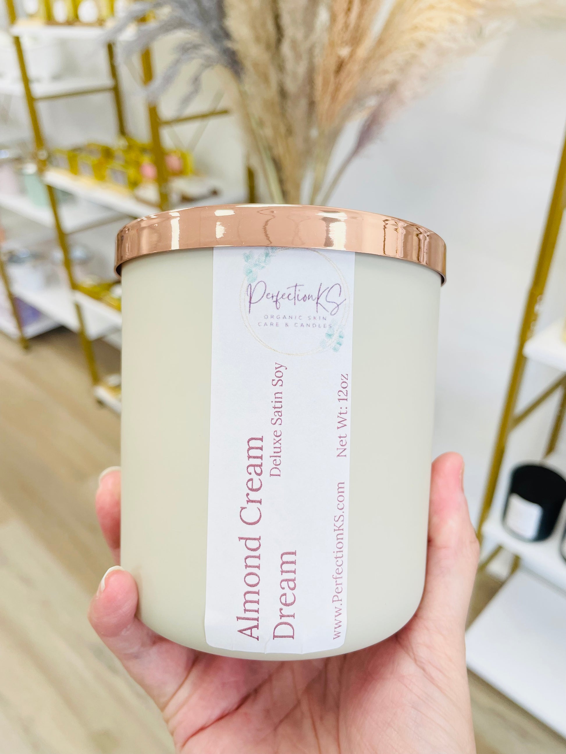 12oz almond cream luxury candle in a sand colored glass container with a rose gold lid