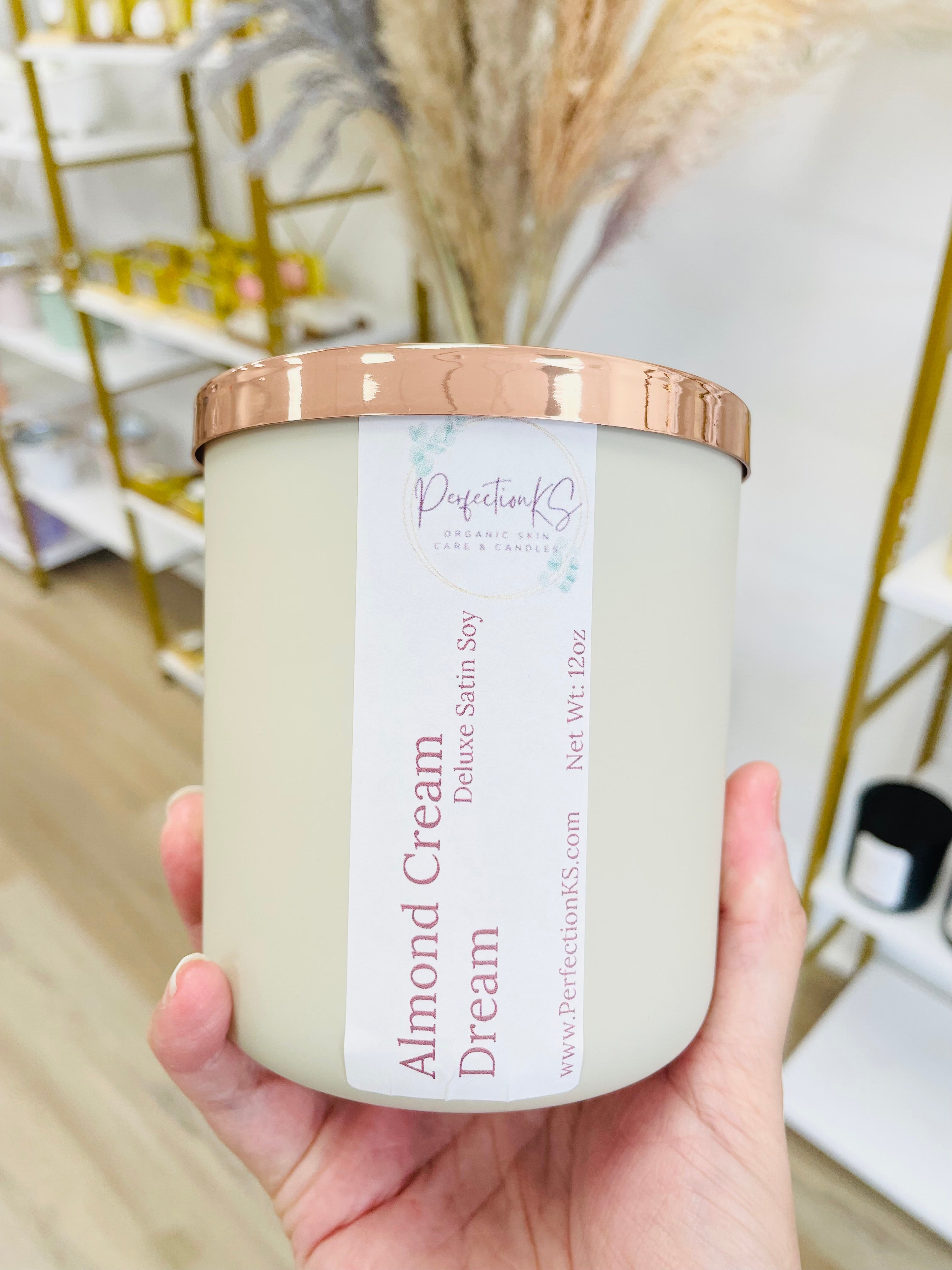 12oz almond cream luxury candle in a sand colored glass container with a rose gold lid