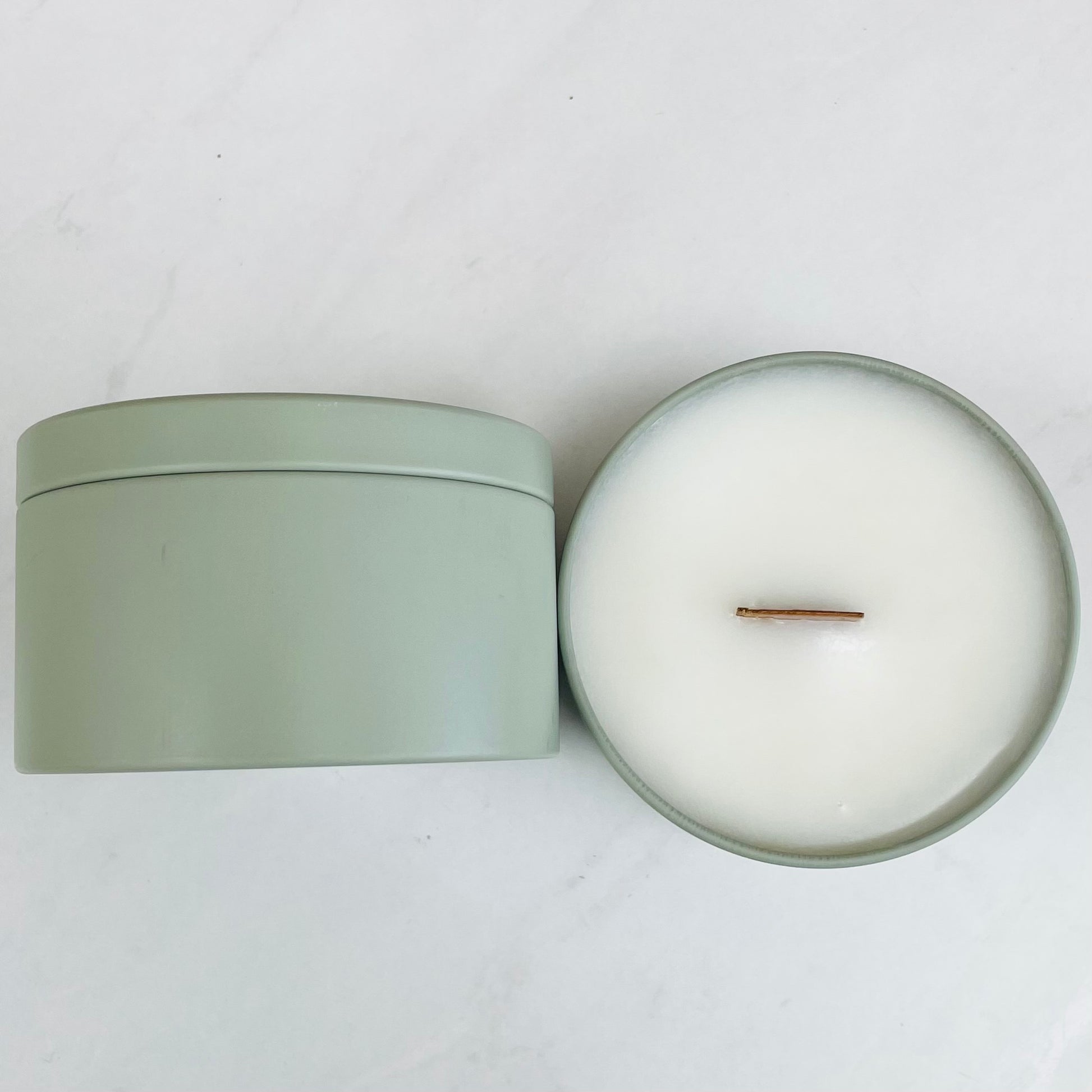 8oz aqua linen luxury candle inside a matte sage metal tin